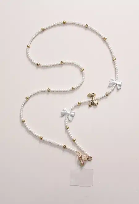 Cordon de téléphone perles & nœuds blancs – Élégant avec détails dorés